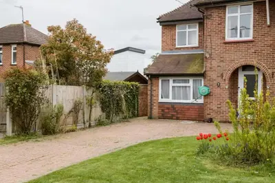 a brick house with a fence and a yard at Fourwinds in Maldon