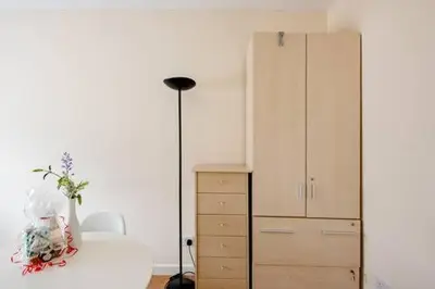 a bedroom with a dresser and a lamp next to a cabinet at Fourwinds in Maldon