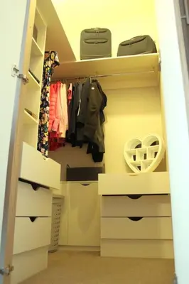 a walk in closet with white cabinets and clothes at Platinum lodge on Carlton Meres holiday Park in Rendham