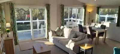 a living room with a couch and a table at Platinum lodge on Carlton Meres holiday Park in Rendham