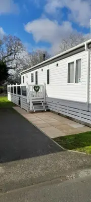 a white mobile home with a porch on a driveway at Platinum lodge on Carlton Meres holiday Park in Rendham