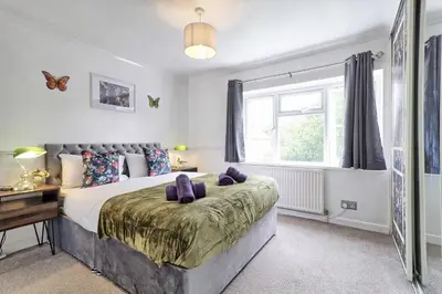 a bedroom with a large bed and a window at Elegant 3 Bedroom House in Basildon - Essex Free Parking & Superfast Wifi, upto 6 Guests in Basildon