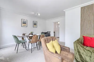 a living room with a dining room table and chairs at Elegant 3 Bedroom House in Basildon - Essex Free Parking & Superfast Wifi, upto 6 Guests in Basildon