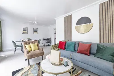 a living room with a couch and a table at Elegant 3 Bedroom House in Basildon - Essex Free Parking & Superfast Wifi, upto 6 Guests in Basildon