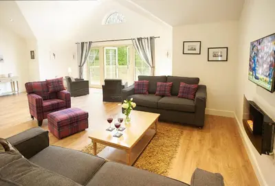 a living room with two couches and a table at Brook Lodge Essex in Chappel