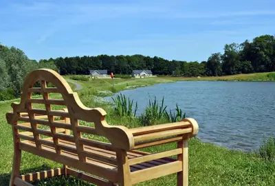 a wooden bench sitting next to a lake at Endymion Lodge in Chappel