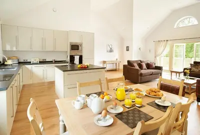 a kitchen and a living room with a table and chairs at Endymion Lodge in Chappel