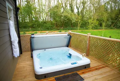 a hot tub sitting on a deck with a view at Endymion Lodge in Chappel