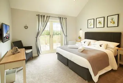 a bedroom with a large bed and a window at Endymion Lodge in Chappel