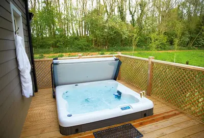 a hot tub on a deck with a view of a yard at Woodbell Lodge in Chappel