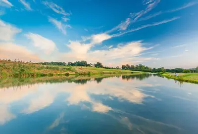 a river with a reflection of clouds in the water at Woodbell Lodge in Chappel