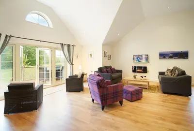 a living room with couches and chairs and a window at Campion Lodge in Chappel