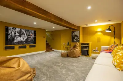 a living room with yellow walls and a couch at The Farmhouse, Nether Hall Estate in Pakenham