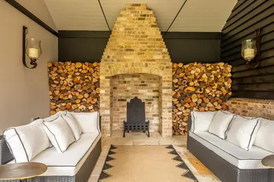 a living room with a fireplace and two couches at The Farmhouse, Nether Hall Estate in Pakenham