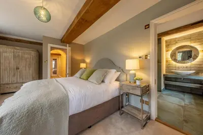 a bedroom with a large bed and a sink at The Farmhouse, Nether Hall Estate in Pakenham