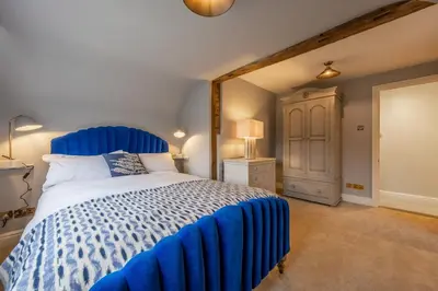 a bedroom with a blue bed with a blue comforter at The Farmhouse, Nether Hall Estate in Pakenham