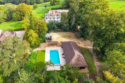 an aerial view of a house with a swimming pool at The Farmhouse, Nether Hall Estate in Pakenham