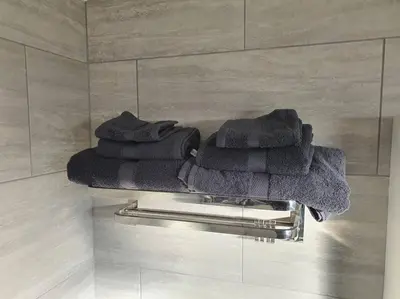 a group of towels sitting on a towel rack in a bathroom at Awave From It All - Escape the city life in Jaywick Sands