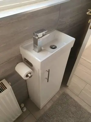 a bathroom with a white sink and a toilet at Awave From It All - Escape the city life in Jaywick Sands