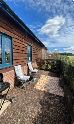 a patio with two chairs and a rug at Willow Barn luxury countryside accommodation in Bury St Edmunds in Bury Saint Edmunds