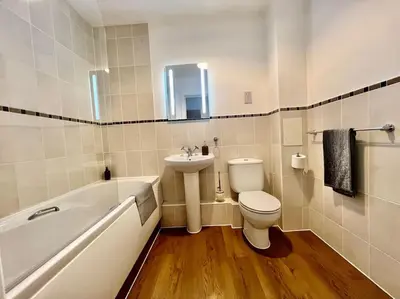 a bathroom with a toilet and a sink and a tub at Home2home - Mill Park in Cambridge
