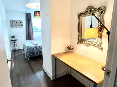 a room with a mirror on the wall and a table at Home2home - Mill Park in Cambridge