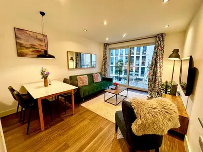 a living room with a green couch and a table at Home2home - Mill Park in Cambridge