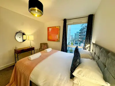 a bedroom with a large bed with a window at Home2home - Mill Park in Cambridge