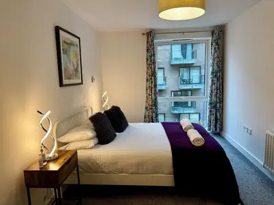 a bedroom with a large bed and a window at Home2home - Mill Park in Cambridge