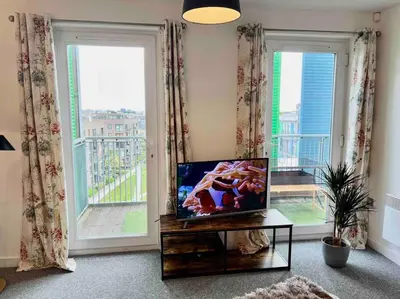a living room with a tv and a large window at Home2home - Mill Park in Cambridge