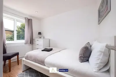 a white bedroom with a bed and a window at Centrally Located 3 Bedroom House By Trinity Stays Short Lets & Serviced Accommodation Cambridge in Cambridge