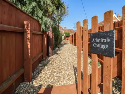 a fence with a sign that reads animals cottage at Admiral Cottage in Woodbridge