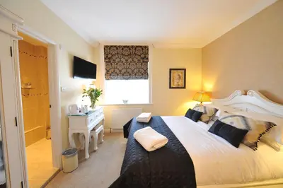a bedroom with a large bed and a window at Le Bouchon Brasserie & Hotel in Maldon
