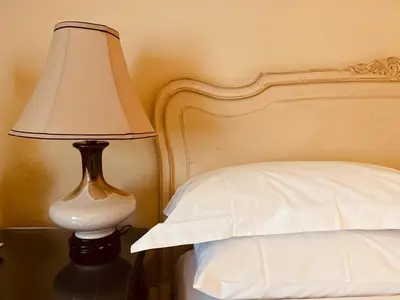 a lamp sitting on a table next to a bed at Le Bouchon Brasserie & Hotel in Maldon