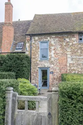 a brick house with a fence in front of it at Toll Barn, St Osyth Priory in Colchester