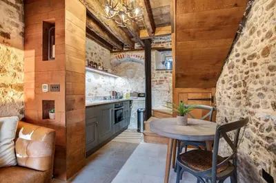 a kitchen with wooden walls and a table and chairs at Toll Barn, St Osyth Priory in Colchester