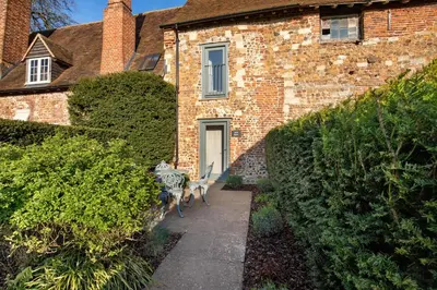 two dogs walking down a sidewalk in front of a building at Toll Barn, St Osyth Priory in Colchester