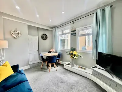 a living room with a blue couch and a tv at Deluxe Apartment in Southend-On-Sea by Artisan Stays I Free Parking I Sleeps 5 in Southend-on-Sea