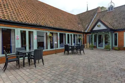 a patio with a table and chairs in a building at Best Western The George Hotel, Swaffham in Swaffham