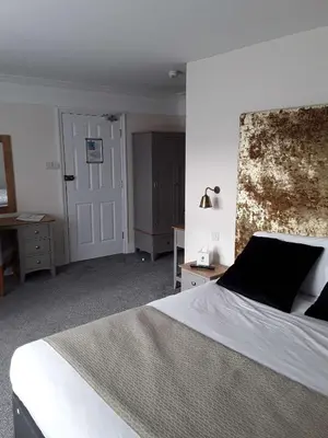 a bedroom with a large bed and a door at Best Western The George Hotel, Swaffham in Swaffham