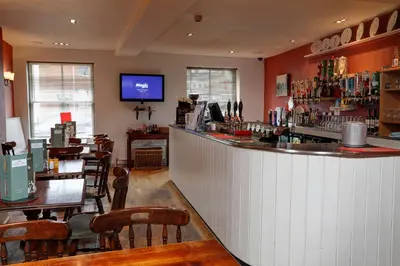 a bar in a restaurant with tables and chairs at Best Western The George Hotel, Swaffham in Swaffham