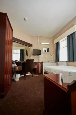 a hotel room with a bed and a desk at Best Western The George Hotel, Swaffham in Swaffham