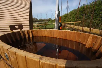 a wooden plunge pool with a bottle of wine at Armadilla 2 at Lee Wick Farm Cottages & Glamping in Clacton-on-Sea