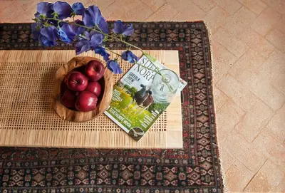 a bowl of apples and a book on a table at Blacksmith's Cottage Suffolk in Lavenham