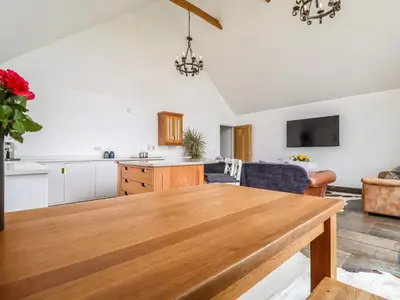 a kitchen and living room with a wooden table at Polly's Annexe in Ipswich