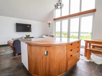 a kitchen with a large island in a room with windows at Polly's Annexe in Ipswich