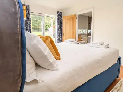 a bedroom with a large bed with white pillows at Polly's Annexe in Ipswich