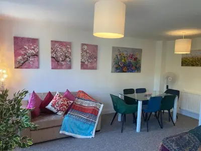 a living room with a couch and a table with chairs at Warm & Cosy Homely 4 BDR Chesterton House w High Speed WIFI, Big Garden & Free Parking in Cambridge