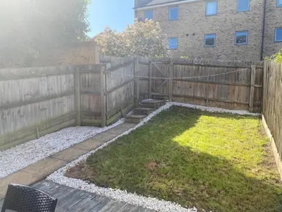 a backyard with a wooden fence and a garden at Warm & Cosy Homely 4 BDR Chesterton House w High Speed WIFI, Big Garden & Free Parking in Cambridge