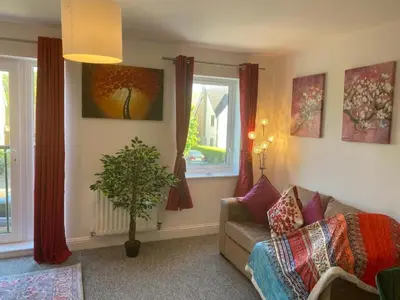 a living room with a couch and a window at Warm & Cosy Homely 4 BDR Chesterton House w High Speed WIFI, Big Garden & Free Parking in Cambridge